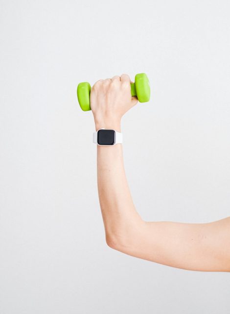 person-wearing-white-apple-watch-while-holding-green-4482936